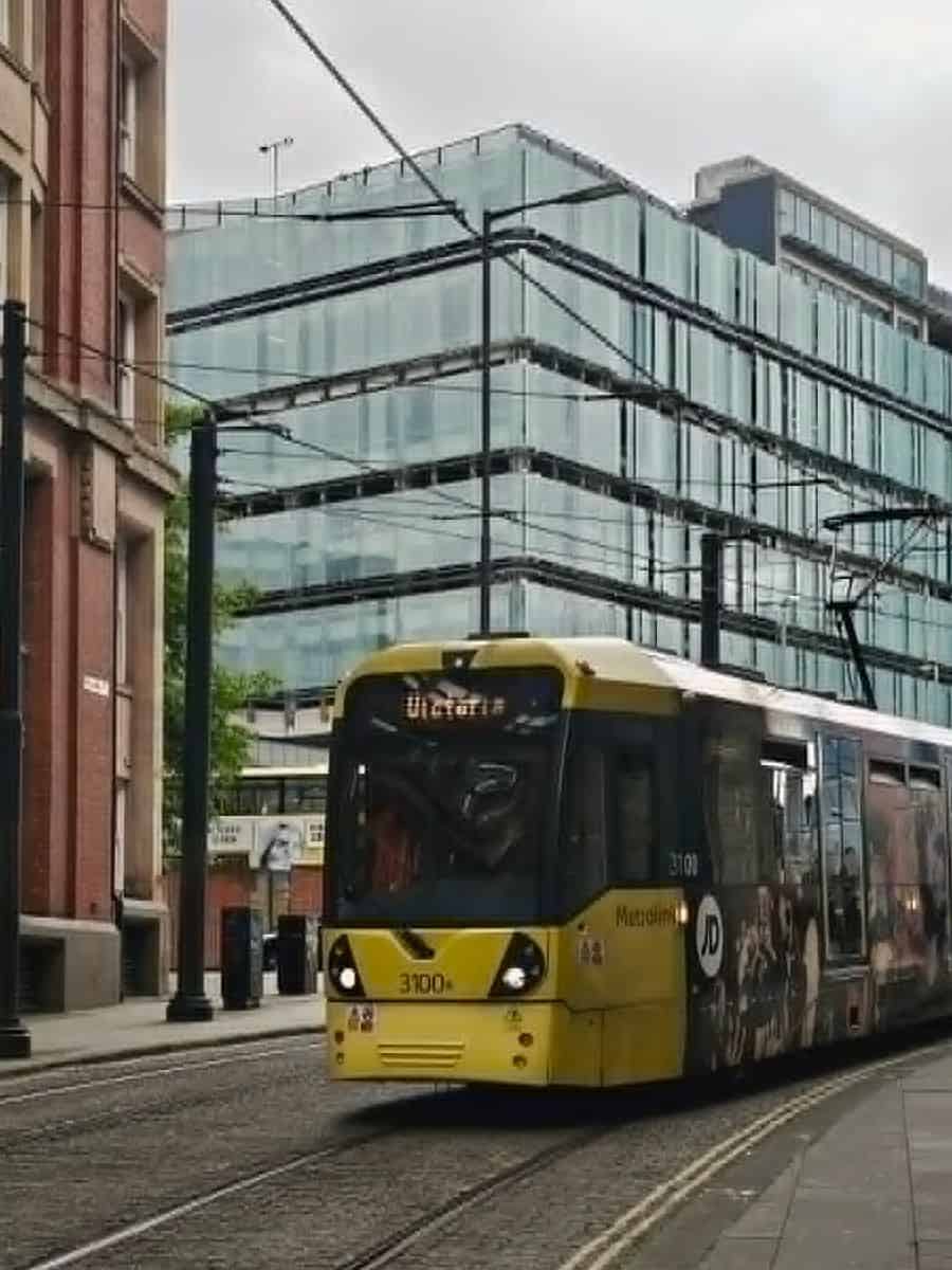 Metrolink tram travelling through Manchester city centre, a useful way to get around for July events and days out.